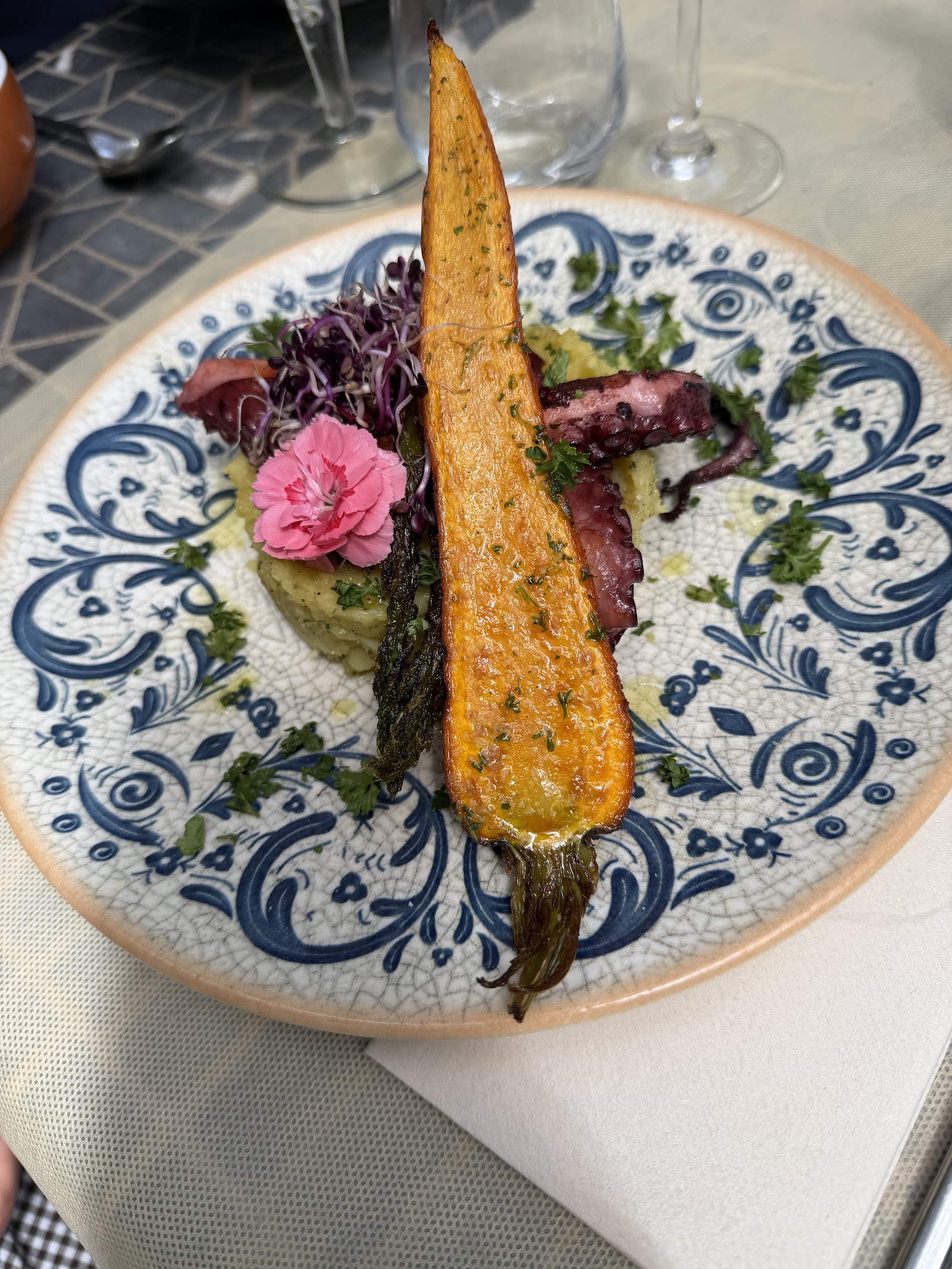 Carotte rôtie dressée sur une assiette en faïence bleue à motifs