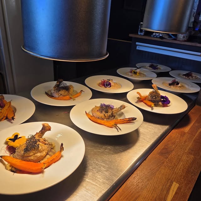 Assiettes alignées au passe de la cuisine, prêtes à partir en salle