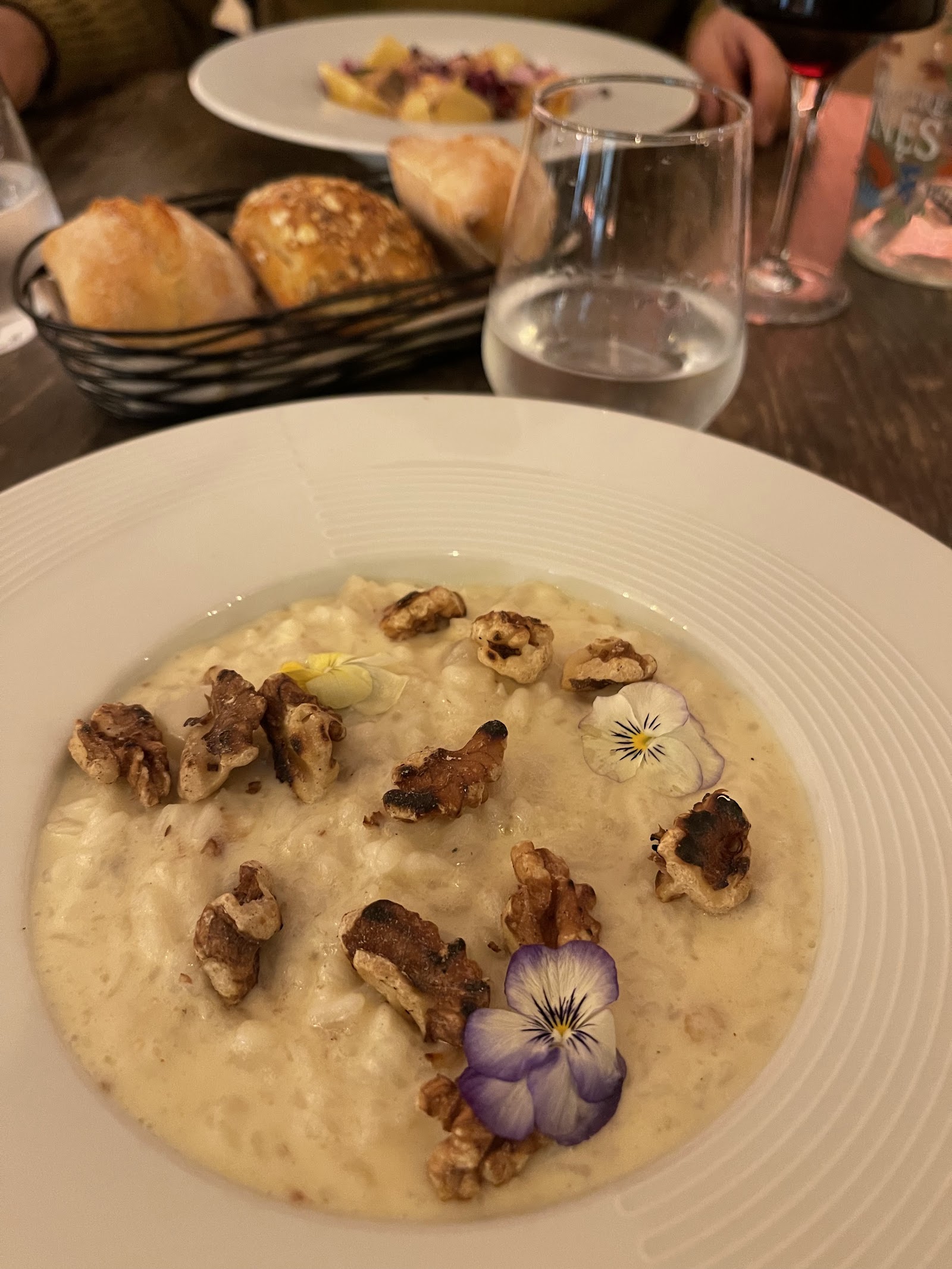 Risotto crémeux garni de noisettes et d'une fleur comestible